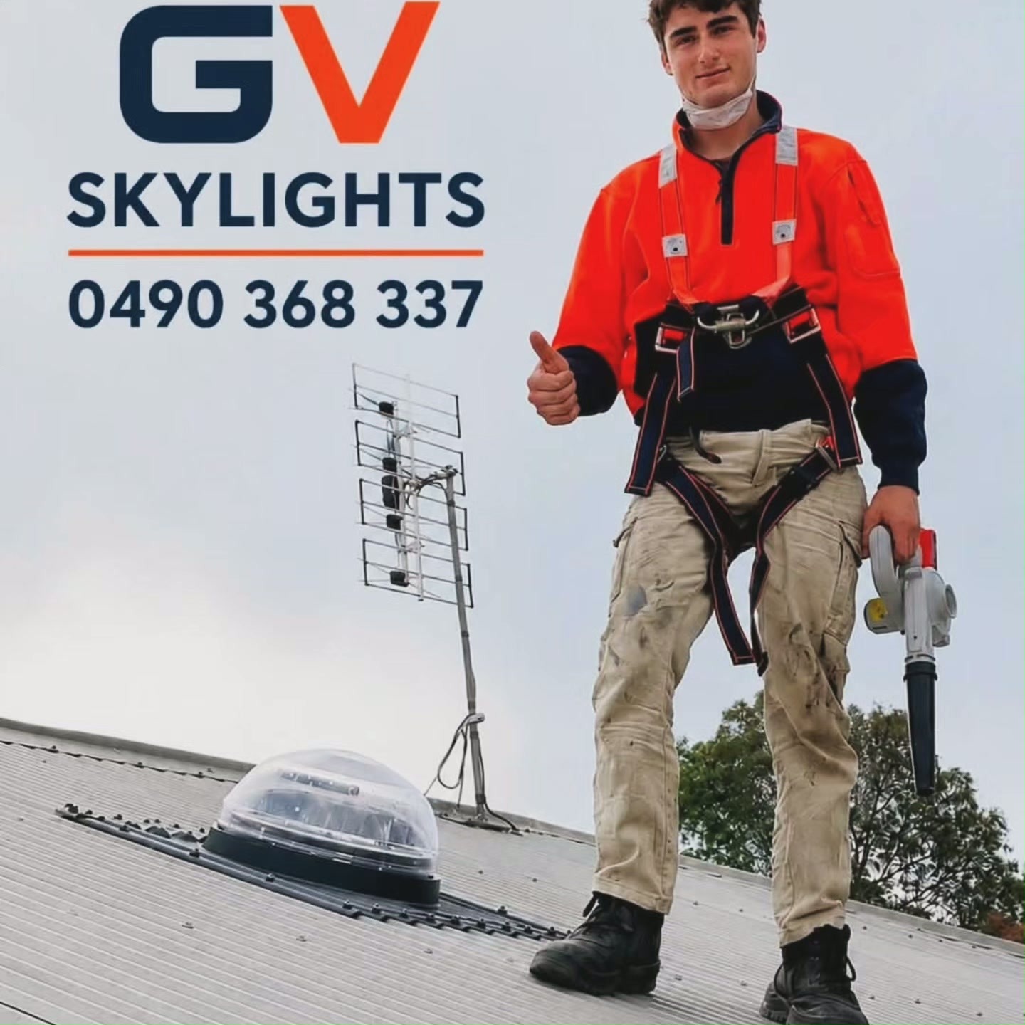 GV Skylights installer on a metal roof beside a newly fitted Solatube dome
